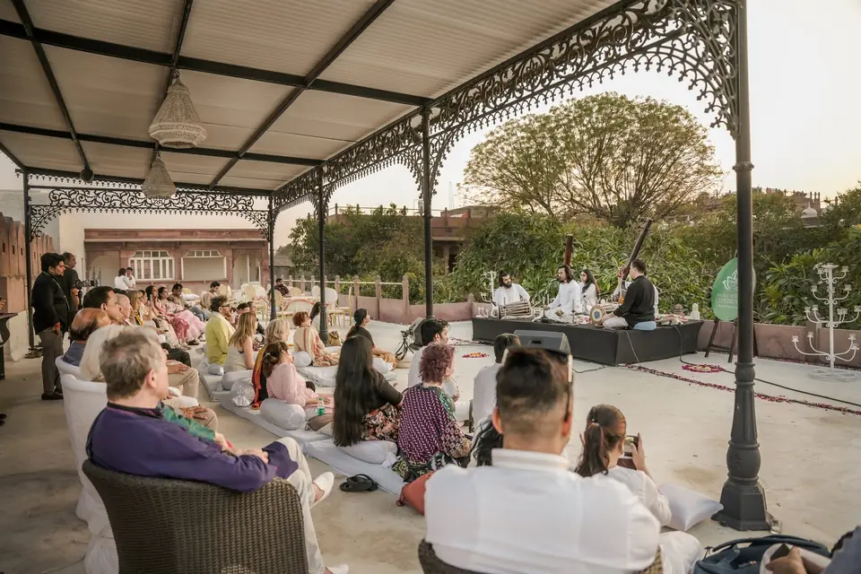 Guests listening under the wrought-iron pavilion