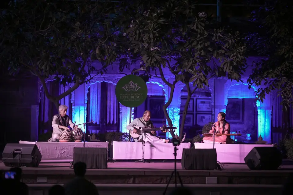 Musicians on the main stage, lit violet beneath the trees