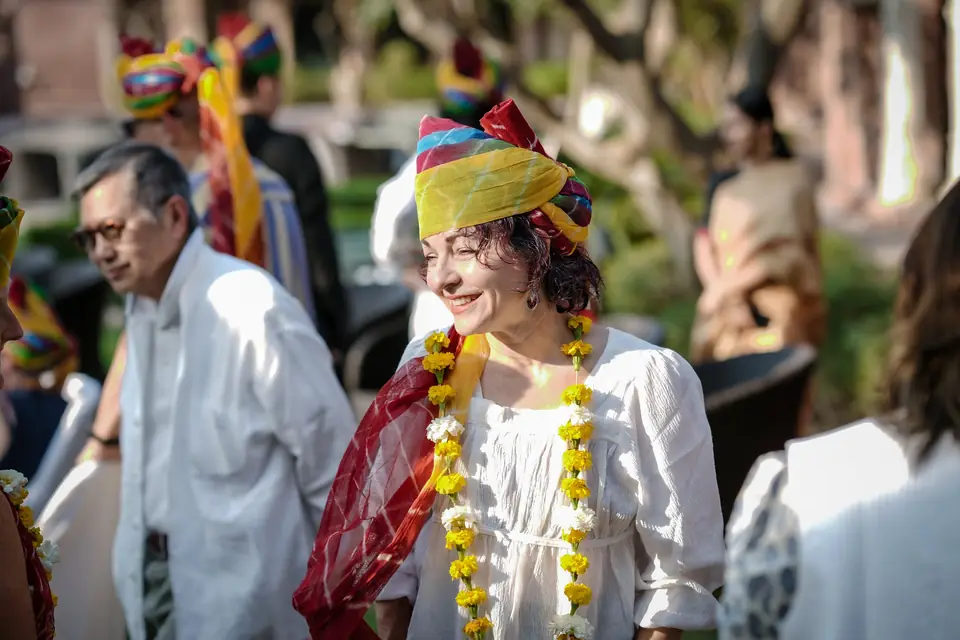 A smiling guest in a newly tied Rajasthani turban and garland