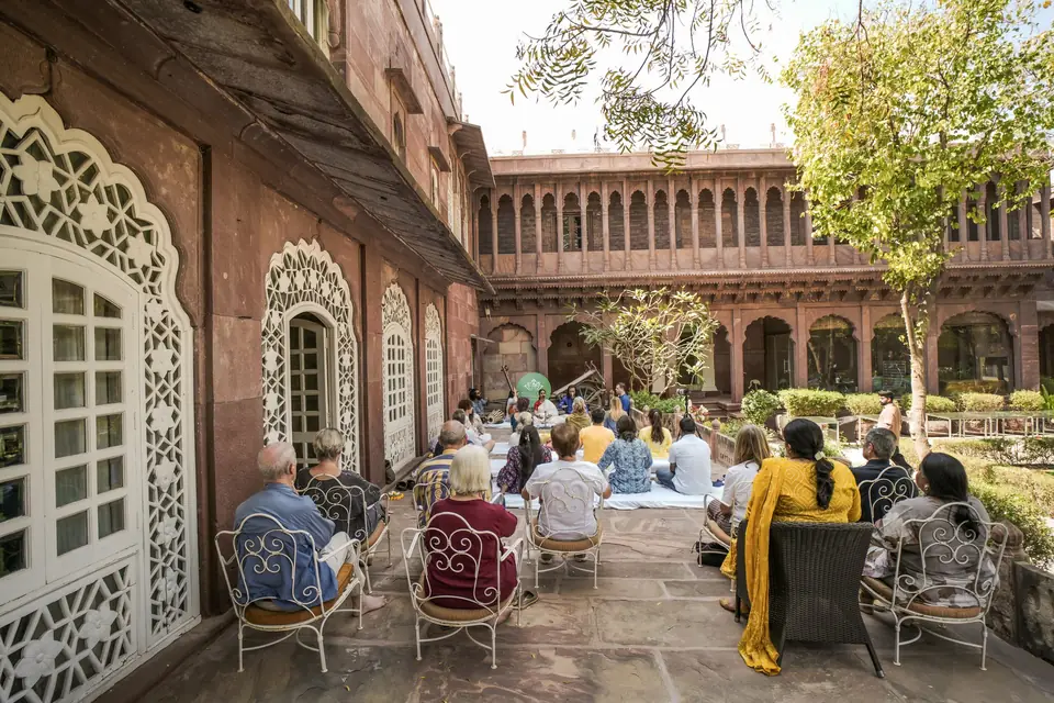 Guests gathered on chairs and cushions in the courtyard