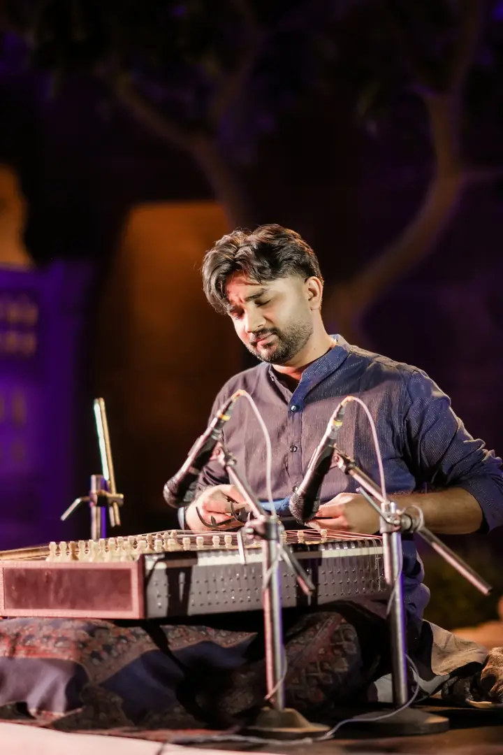 A santoor player under the stage lights