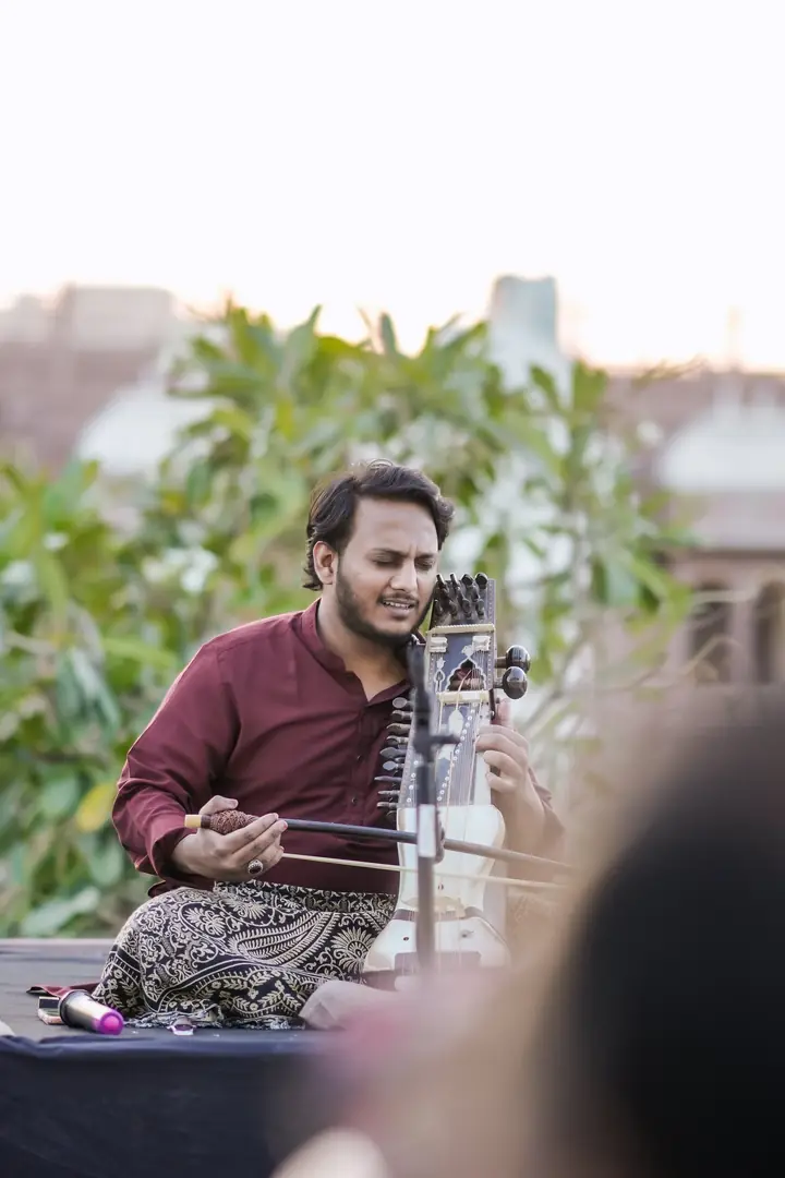 A sarangi player, bow drawn across the strings