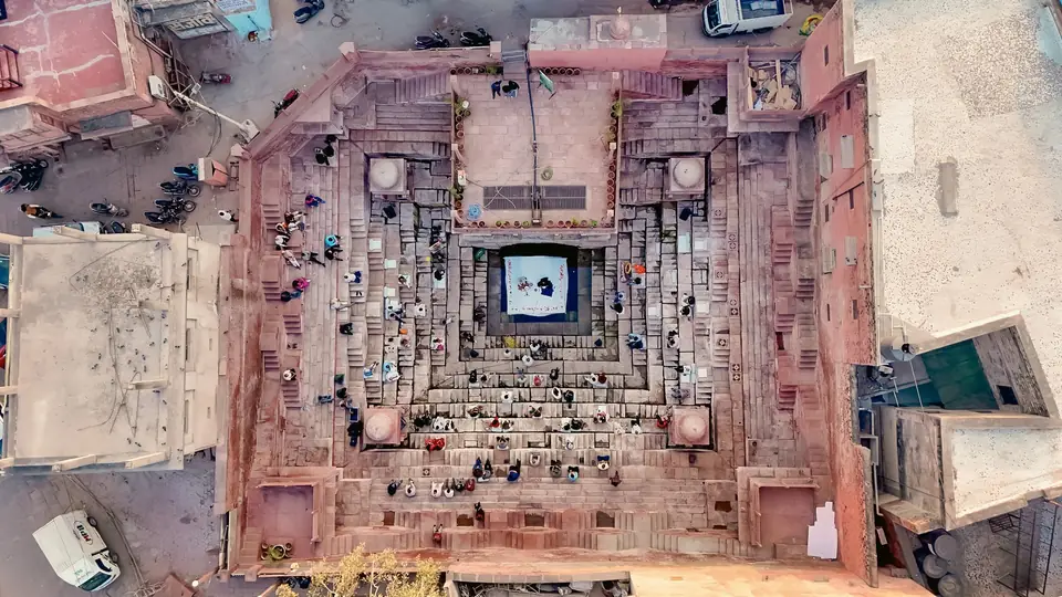An old stepwell from directly above, guests on its terraces