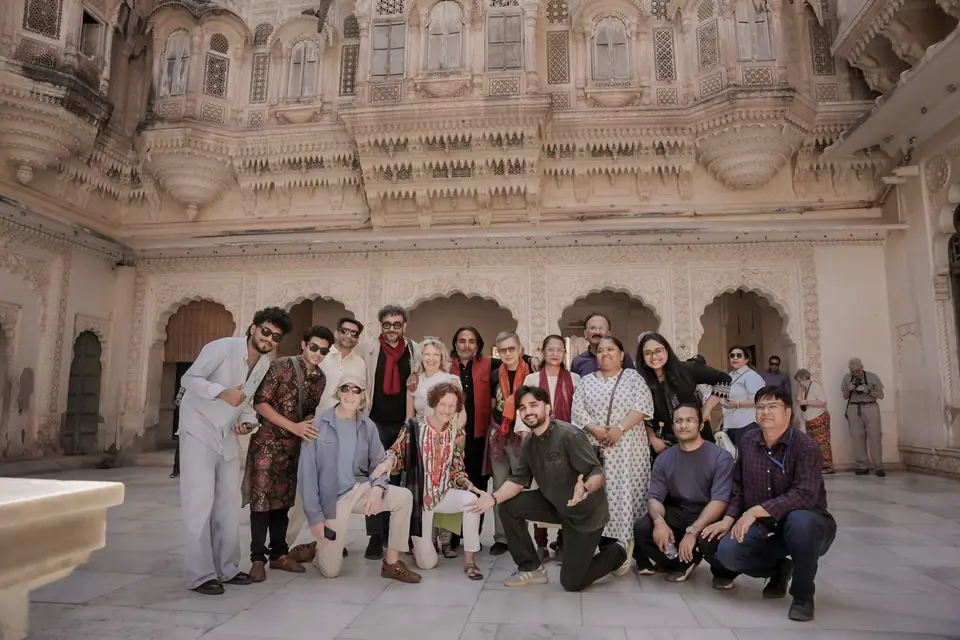 Guests and musicians together in a carved palace courtyard