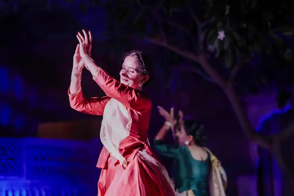 A dancer in red, arms raised