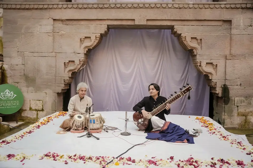 Sitar and tabla on a carpet of petals at the foot of the stepwell