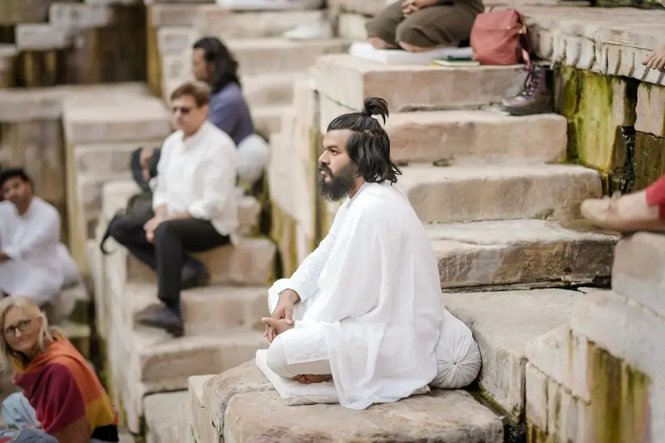 A guest seated in meditation on the stone steps