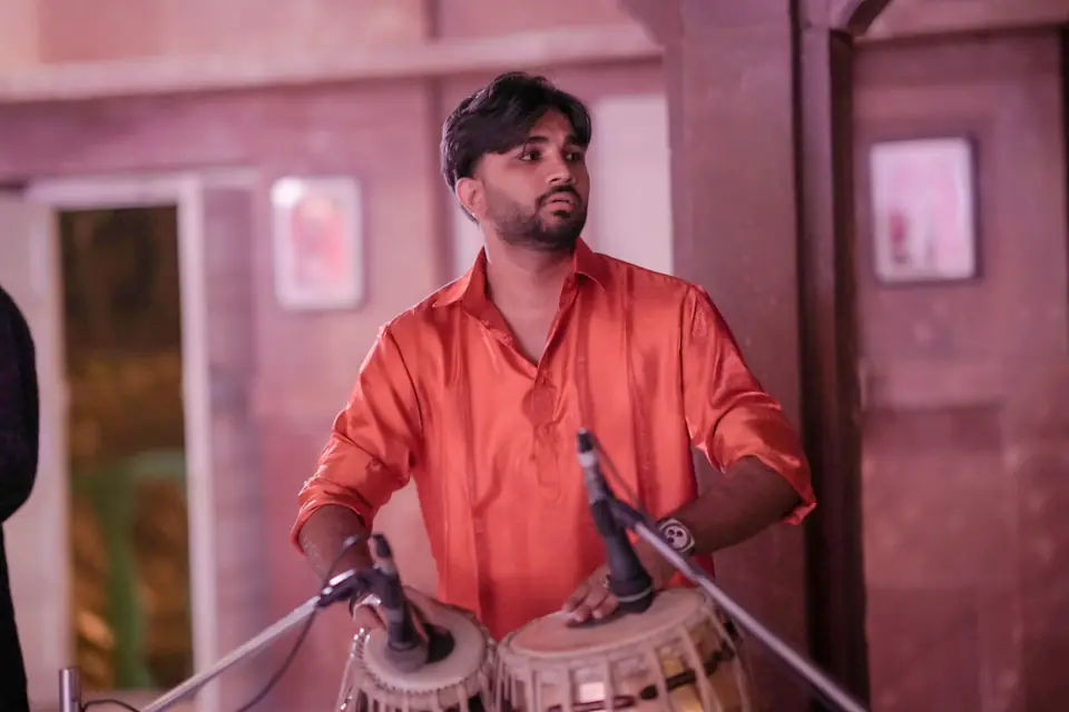 A tabla player in red light
