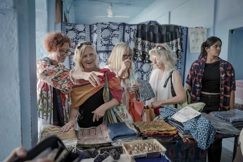 Guests trying on block-printed textiles at a market stall