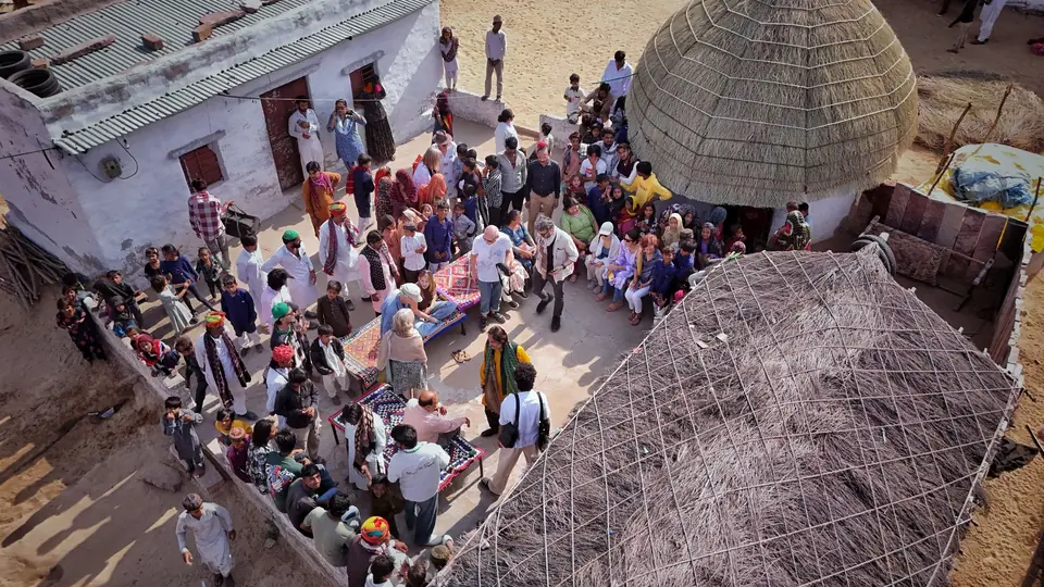 Guests gathered in a village courtyard, seen from above