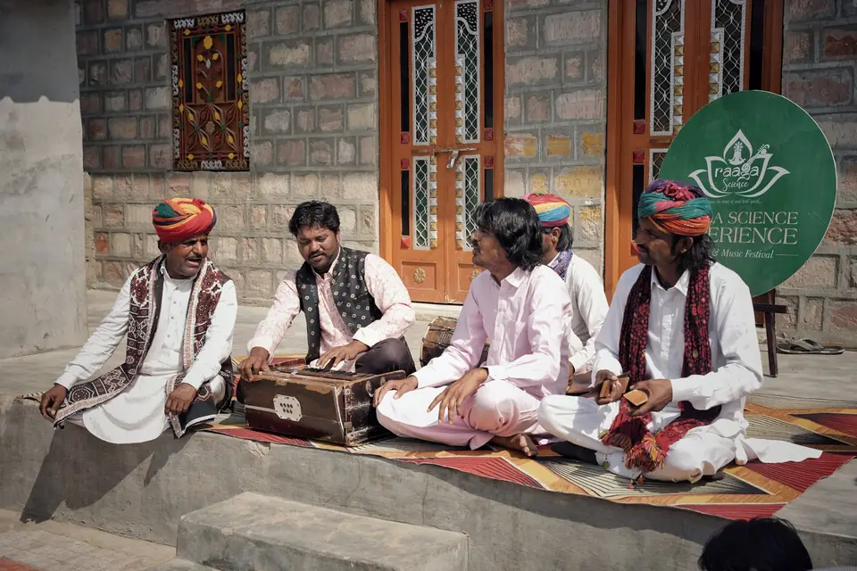 Musicians with harmonium on the porch of a village house