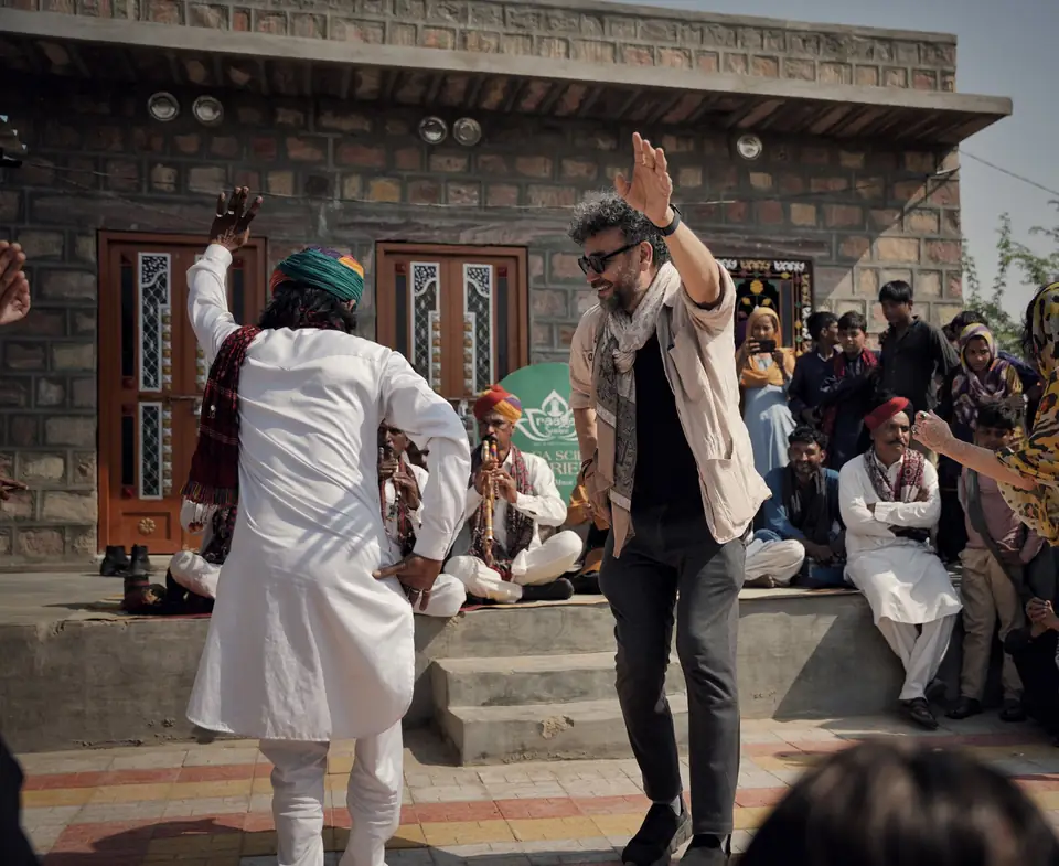 A guest and a musician dancing together in the courtyard