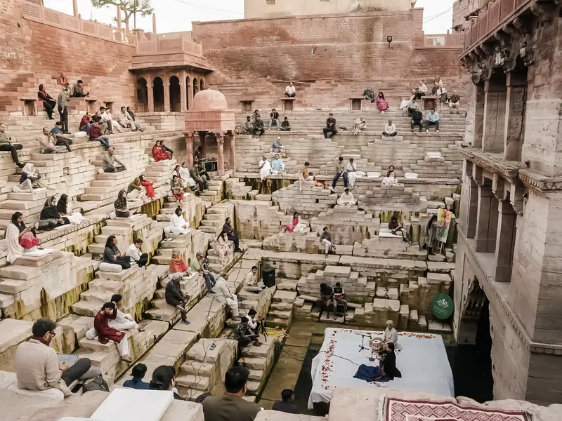 A concert at the foot of an old stepwell, guests seated on the steps above