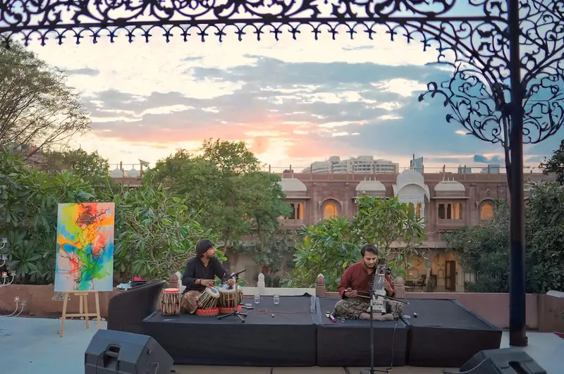 A sunset raaga on the rooftop at Pal Garh, tabla and a bowed string instrument against a pink evening sky